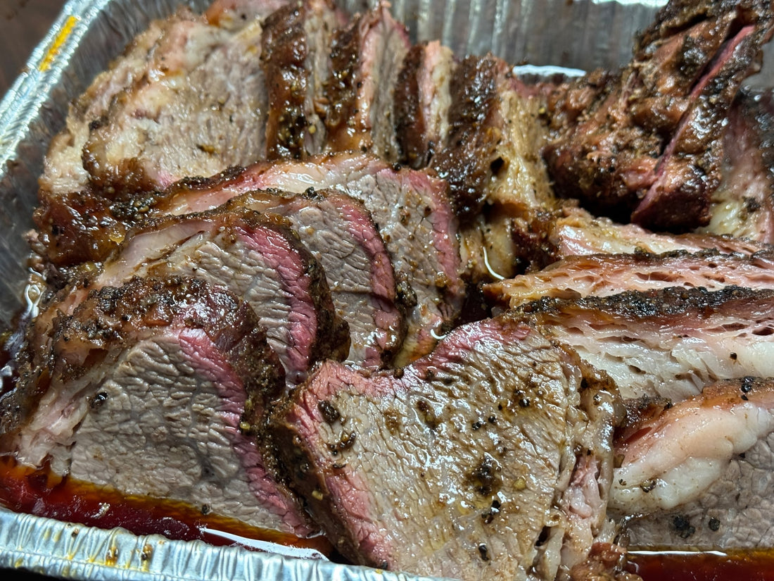 Smoked tri-tip prepared “like brisket” (Trisket), showing a barked exterior with deep smoke ring and juicy sliced interior, seasoned with BBQ rubs for a tender, brisket-style smoked beef presentation.