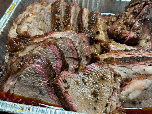 Smoked tri-tip prepared “like brisket” (Trisket), showing a barked exterior with deep smoke ring and juicy sliced interior, seasoned with BBQ rubs for a tender, brisket-style smoked beef presentation.