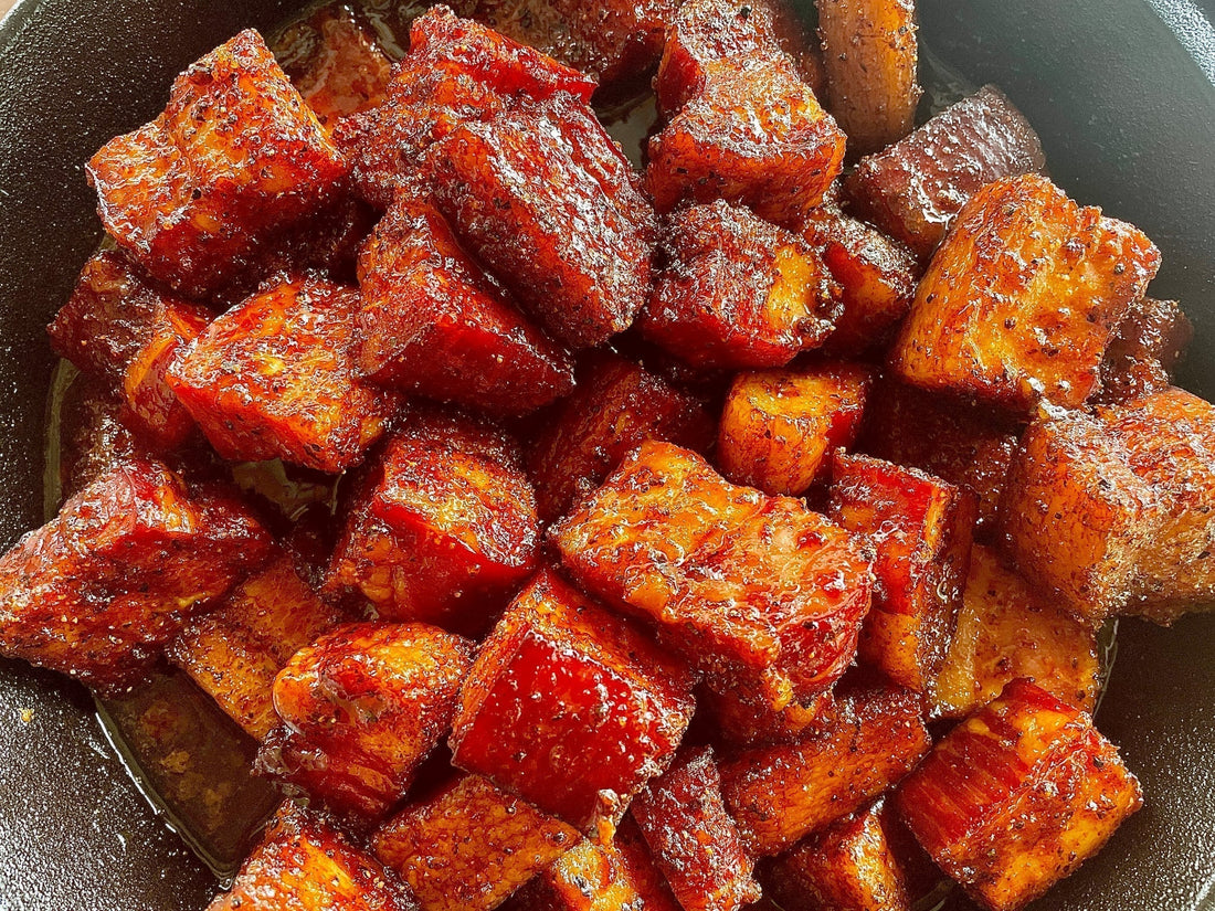 Smoked pork belly burnt ends glazed with a sweet and smoky apple chipotle sauce, showing caramelized edges, a glossy sticky finish, and a tender bite-sized texture, representing rich sweet-heat BBQ flavor done holy smokers way.