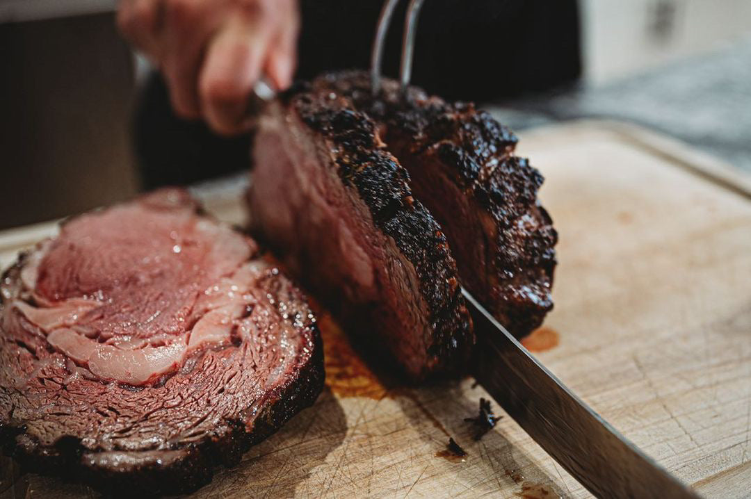 Wood-fired smoked beef roast seasoned with roasted garlic and herb rub, showing a smoky bark with a juicy interior and a light citrus finish, presented as a bold, flavorful BBQ beef cut.