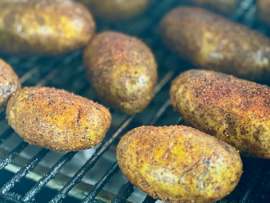 Roasted or smoked potatoes seasoned with Holy Smokers AP Rub, featuring a golden, crispy exterior and tender fluffy center with bold savory BBQ-style seasoning.