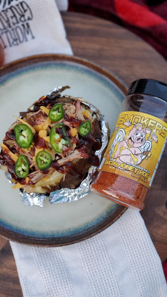 Baked potatoes split open and loaded with tender smoked pulled pork, melted cheddar cheese, and BBQ sauce, finished with a savory seasoning, showing a hearty, smoky comfort food presentation.