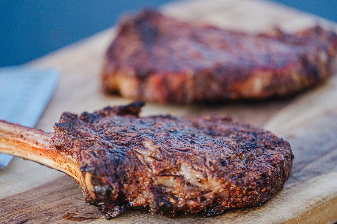 Tomahawk ribeye steak reverse-seared to perfection with a bold BBQ rub crust, showing a thick, bone-in steak with a smoky sear, juicy interior, and rich, caramelized exterior for a premium grilled presentation.