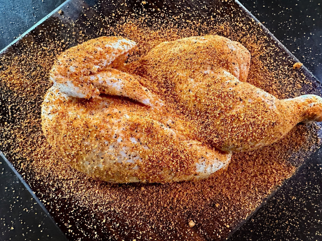 A smoked half BBQ chicken with a caramelized, golden-brown skin, seasoned with apple chipotle BBQ rub, showing a glossy sweet-heat glaze and light smoke infusion, presented as a juicy backyard barbecue chicken half.