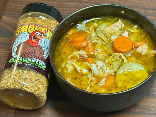 Smoked turkey noodle soup featuring tender chunks of smoked turkey, egg noodles, carrots, celery, and onions in a rich aromatic broth, showing a hearty, comforting bowl with a light smoky and herb-seasoned finish.