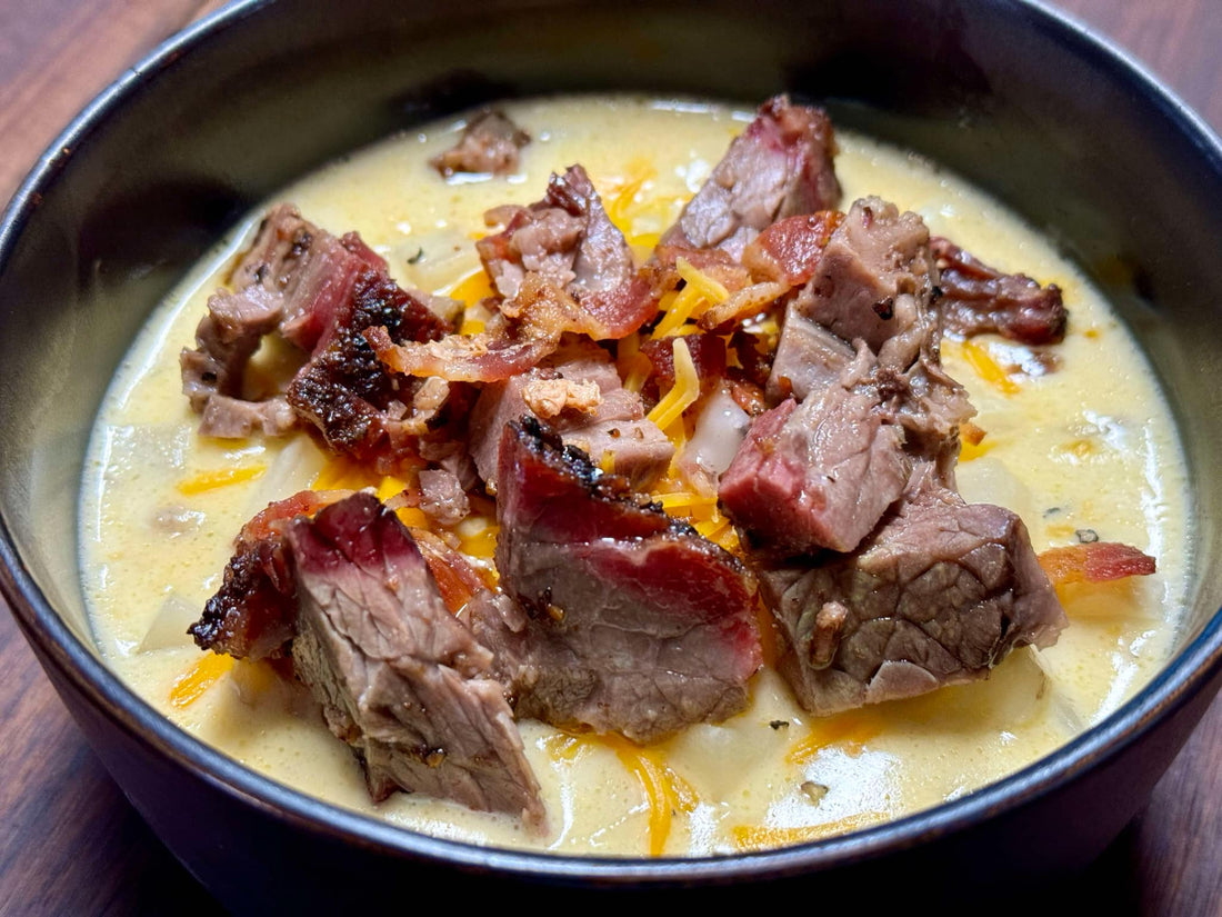 Loaded bacon and brisket potato soup featuring creamy potatoes, smoked brisket chunks, crispy bacon, and melted cheese, showing a thick, hearty bowl of rich comfort food with bold smoky BBQ flavor.