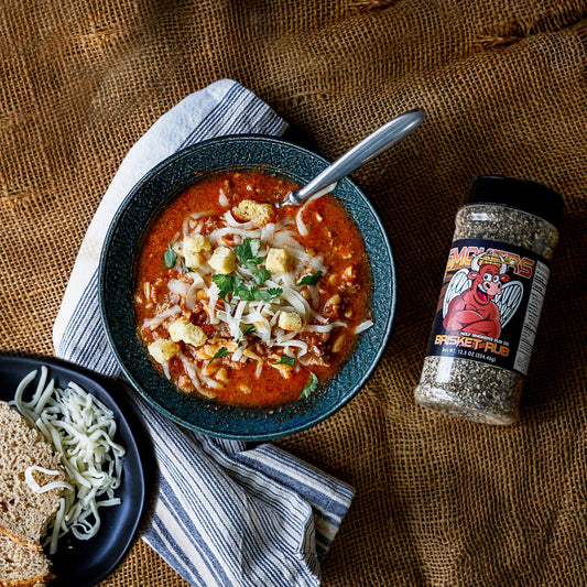 Hearty lasagna soup with ground beef, onions, and red bell peppers simmered in marinara and broth with rotini noodles, topped with melted cheese and croutons, showing a rich, savory, comfort-style bowl with bold BBQ seasoning influence.